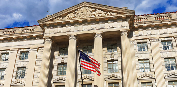 Outdoor shot of a government or political building with American flag flying in front