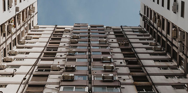 Large apartment building with multiple mini split units in windows