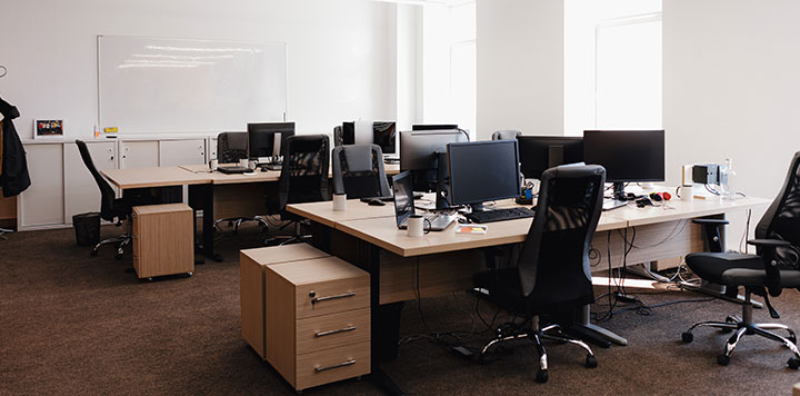 Interior shot of empty office space with mutlipe desks and computers